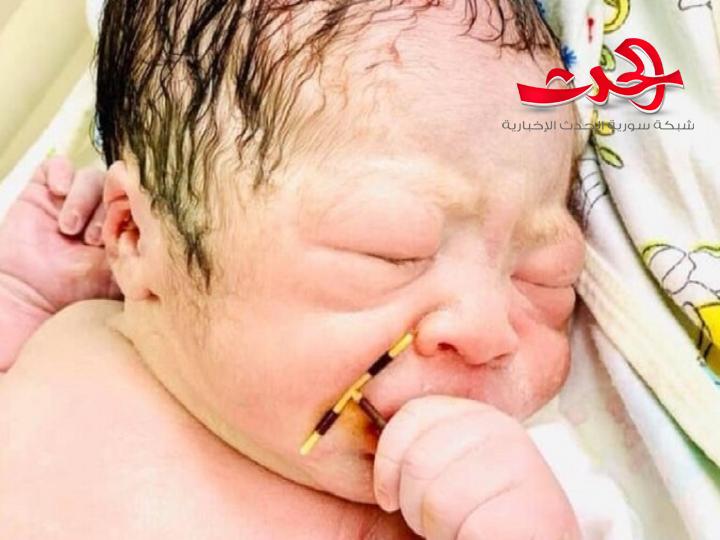 صور لمولود حديث الولادة بحمل وسيلة منع حمل أمه بين يديه